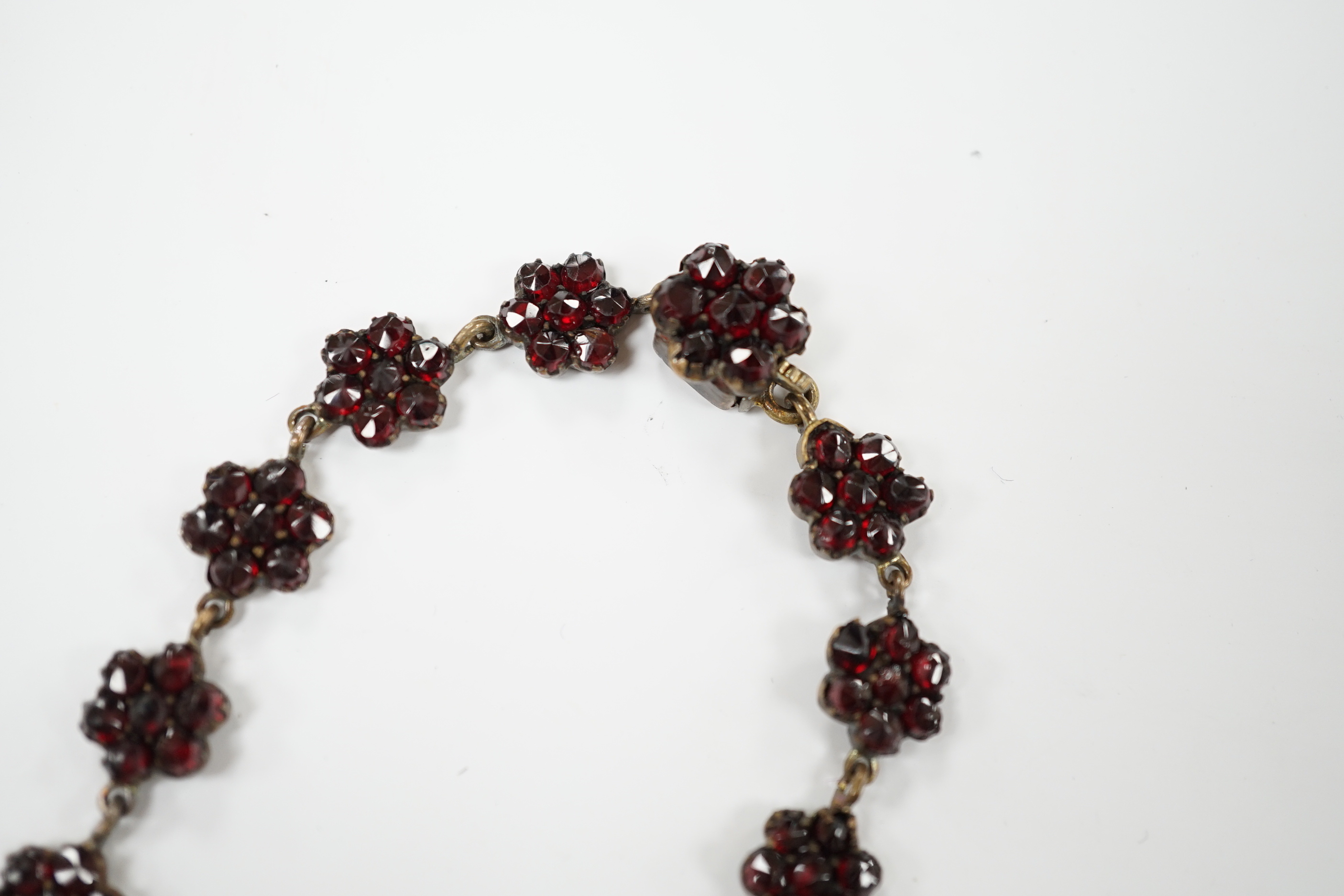 A Victorian garnet set gilt metal and tortoiseshell suite of jewellery comprising bracelet, necklace, ring and two hair combs